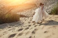 Photoshoot lovers in a wedding dress on the beach near the sea