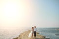 Photoshoot lovers in a wedding dress on the beach near the sea