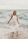 Photoshoot of a pregnant woman walking on the beach