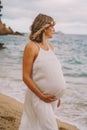 Photoshoot of a pregnant woman walking on the beach