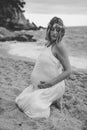 Photoshoot of a pregnant woman walking on the beach