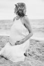 Photoshoot of a pregnant woman walking on the beach