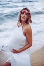 Photoshoot of a pregnant woman walking on the beach