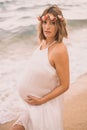 Photoshoot of a pregnant woman walking on the beach