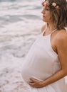 Photoshoot of a pregnant woman walking on the beach