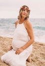 Photoshoot of a pregnant woman walking on the beach