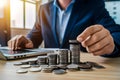 PhotoStock Businessman saving money, coins stacking on desk, finance concept