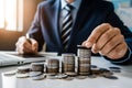 PhotoStock Businessman saving money, coins stacking on desk, finance concept