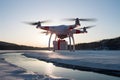 PhotoStock Drone delivers order, medicine, gift, flying over icy river Royalty Free Stock Photo