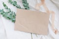 Photostock wedding styled composition. Feminine desktop mockup scene with eucalyptus leaves, silk ribbon, blank brown greeting car