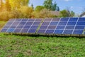 Photovoltaic ecological modules on green grass valley against of sun and cloudy sky Royalty Free Stock Photo