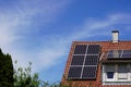 Photovoltaic modules on a roof and the large dormer window, the sun shines on the buildin