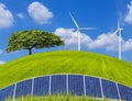 Photovoltaics solar panels with lonely tree and wind turbines on green field Royalty Free Stock Photo