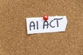 The phrase AI ACT written by hand on a torn paper note and pinned to a corkboard, symbolizing artificial intelligence le Royalty Free Stock Photo