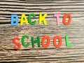 Phrase back to school made from wooden alphabets against wooden background.