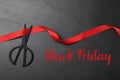 Phrase Black Friday, ribbon and scissors on dark background, flat lay Royalty Free Stock Photo