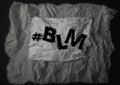 The phrase Black Lives Matter written on a background of crumpled paper