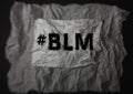 The phrase Black Lives Matter written on a background of crumpled paper