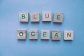 Phrase blue ocean made of wooden pieces on blue background. Business strategy concept. Market innovations idea. Royalty Free Stock Photo