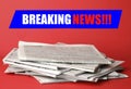 Phrase Breaking News and stack of newspapers on background. Journalist`s work Royalty Free Stock Photo