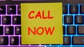The phrase Call now on the yellow paper lying on the keyboard Royalty Free Stock Photo