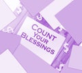 The phrase Count Your Blessings typed on a piece of paper and paper dollar signs around. Career concept