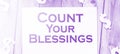 The phrase Count Your Blessings typed on a piece of paper and paper dollar signs around. Career concept