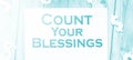 The phrase Count Your Blessings typed on a piece of paper and paper dollar signs around. Career concept