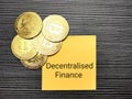 Phrase decentralised finance written on sticky note with golden bitcoins. Royalty Free Stock Photo