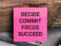 Phrase DECIDE COMMIT FOCUS SUCCEED written on sticky note.