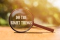 The phrase Do The Right Things typed on a magnifier glass. A reminder to make the right choices according to your moral compass