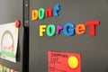 Phrase DON`T FORGET made of magnets on refrigerator door