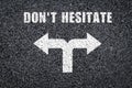 The phrase dont hesitate written on asphalt background