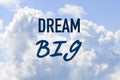 Phrase dream big on a blue clouded sky