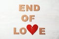 Phrase `End of love` with torn cardboard heart and letters on light background, top view Royalty Free Stock Photo