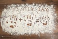 Phrase Family Day and handprints on flour scattered over wooden table, top view