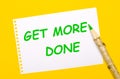 The phrase Get More Done written on a blackboard next to a modern office wall clock. A Time Management concept Royalty Free Stock Photo