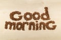 Phrase good morning made with coffee beans on a table top view