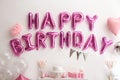 Phrase HAPPY BIRTHDAY made of balloon letters on white wall