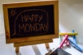 Phrase happy monday written on a chalkboard on it and smartphone, colorful chalk Royalty Free Stock Photo