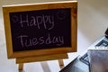 Phrase happy tuesday written on a chalkboard on it and smartphone, laptop Royalty Free Stock Photo