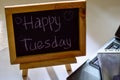 Phrase happy tuesday written on a chalkboard on it and smartphone, laptop Royalty Free Stock Photo