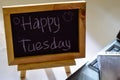 Phrase happy tuesday written on a chalkboard on it and smartphone, laptop Royalty Free Stock Photo