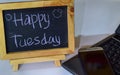 Phrase happy tuesday written on a chalkboard on it and smartphone, laptop Royalty Free Stock Photo