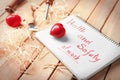 Phrase Health and safety at work written in notebook, tools and red hearts on wooden background