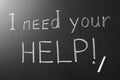 Phrase `I need your help` written on chalkboard