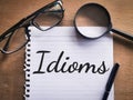 Phrase IDIOMS written on a piece of paper Royalty Free Stock Photo