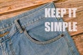 Phrase KEEP IT SIMPLE written on blue jeans and wooden background Royalty Free Stock Photo