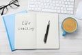 Phrase Life Coaching written in notebook, pen, cup of coffee, glasses and keyboard on white wooden table, flat lay Royalty Free Stock Photo