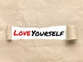 Phrase LOVE YOURSELF appearing behind torn brown paper. Royalty Free Stock Photo